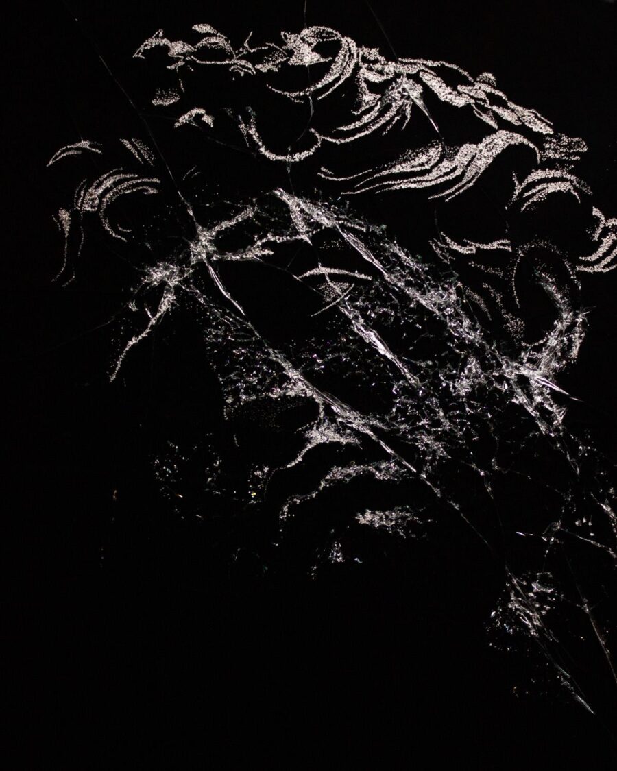 Apollon — the curls and profile of the god drawn in fractured glass on black