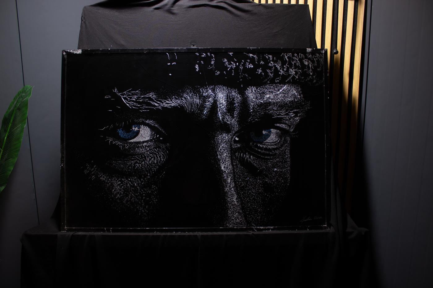 The gaze of the Atatürk portrait in broken glass, lit in the studio