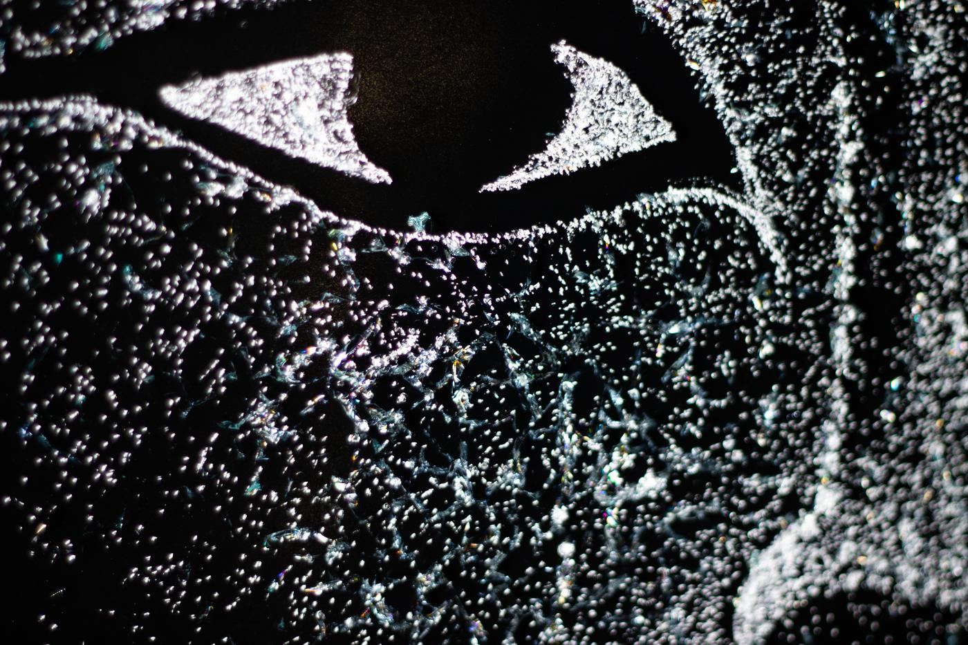 Detail of an eye drawn in fractured laminated glass