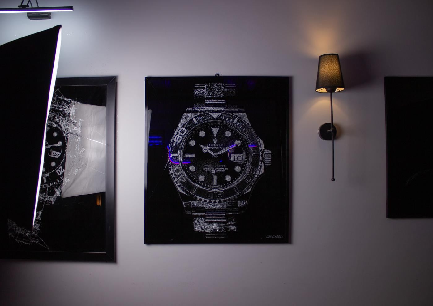 A broken glass artwork of a wristwatch between two wall lights