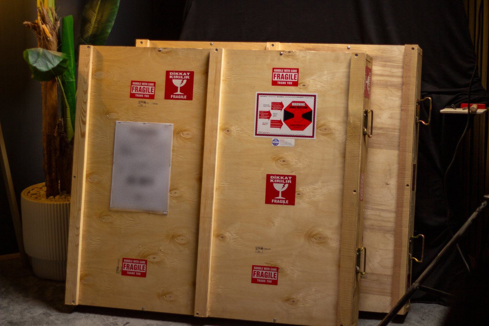 Face avant d’une caisse de transport en bois Cracasso avec indicateur de choc et étiquettes « fragile »