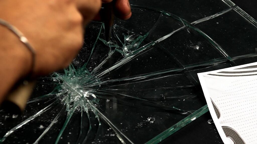 Radiale Risse, die sich von einem einzigen Aufschlagpunkt im Verbundglas ausbreiten
